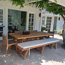 Custom luxury off-white outdoor bench cushion with ties on a rustic wooden patio dining set