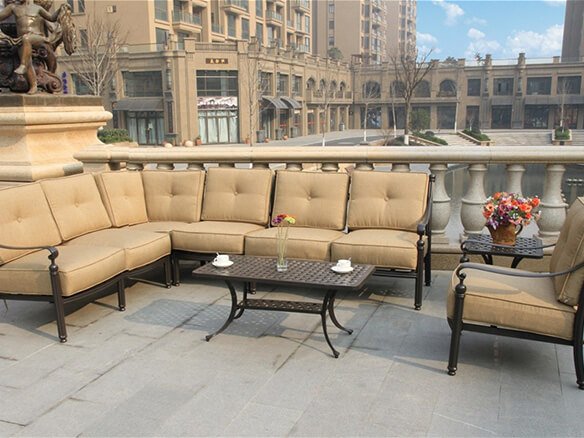 High-density beige tufted cushions on a dark metal modular outdoor sofa set in a luxury patio setting.